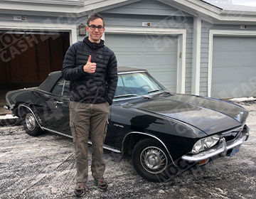 man standing next to his sold classic vehicle