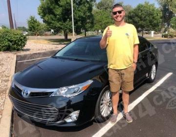 happy customer standing next to his sold Toyota Avalon