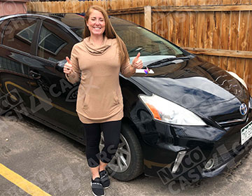 Happy customer next to her sold Toyota Prius